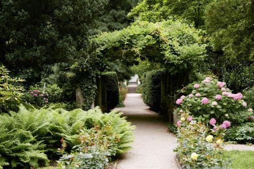 a garden with a path with flowers and plants at Parkhotel Laurin in Bolzano