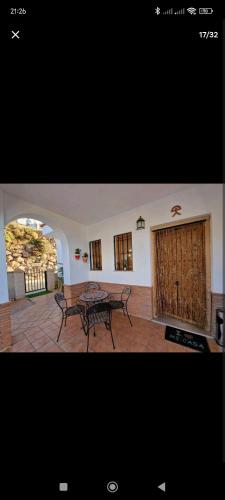 een woonkamer met een tafel en een patio bij El mirador del beregenal in Enix