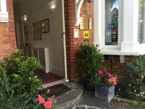 a front door of a house with flowers on the porch at Croham Park B&B - Free Parking & Wi-Fi in Croydon