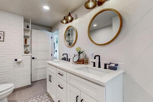 ein weißes Badezimmer mit einem Waschbecken und einem Spiegel in der Unterkunft Erikson Beach House in Bow