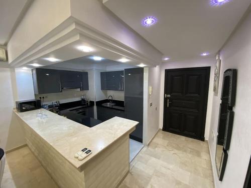 een keuken met een aanrecht en een zwarte deur bij Luxury Marina Appartement Agadir in Agadir
