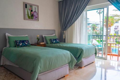 two beds in a bedroom with a balcony at Luxury Marina Appartement Agadir in Agadir