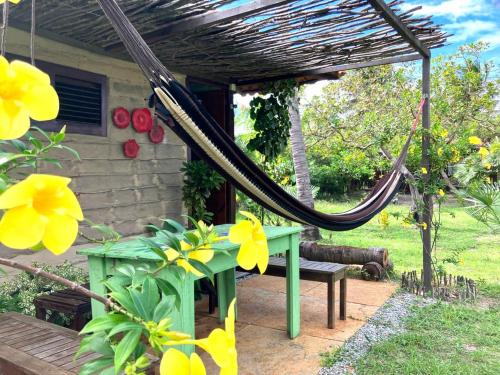 - une terrasse couverte avec un hamac, un banc et des fleurs dans l'établissement Maré de Atins Eco Lodge, à Atins