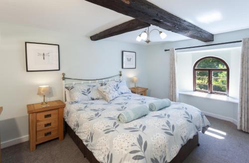 a bedroom with a bed and a window at Barn Owl Cottage Wheddon Cross in Wheddon Cross