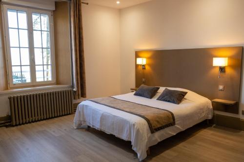 a bedroom with a bed and a large window at Logis - Hotel Restaurant La Sapinière in Wisques