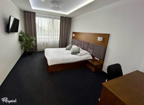 Cette chambre comprend un lit et un bureau. dans l'établissement Hotel Crystal, à Janikowo