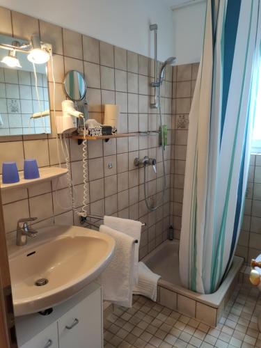 ein Badezimmer mit Badewanne, Waschbecken und Dusche in der Unterkunft Schlei-Liesels Ferienwohnungen in Güby