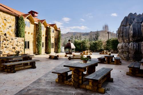 un grupo de mesas de picnic en un patio en Wood Hills Hotel & Resort, en Mayrūbā