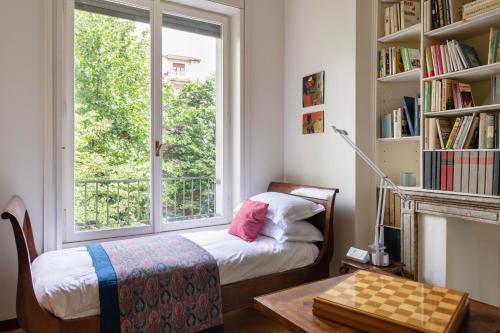 een kleine slaapkamer met een bed en een raam bij Milano Classy Heritage Home, City Center in Milaan