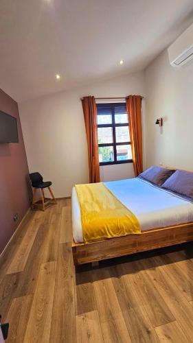 une chambre avec un grand lit et une fenêtre dans l'établissement Les Marronniers, à Lavérune