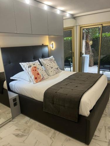 une chambre avec un grand lit avec des oreillers dans l'établissement Chic 47m2, 2 rooms, ground floor, nice patio, 280m beach Croisette, à Cannes
