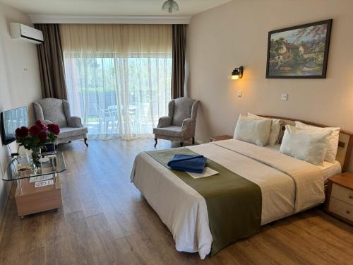 a hotel room with a large bed and two chairs at High Life in Kyrenia