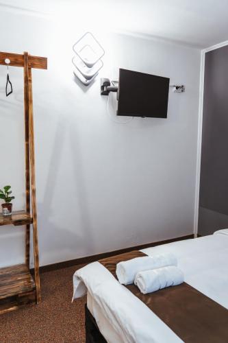 a room with two beds and a tv on the wall at Casa Rosu in Cluj-Napoca