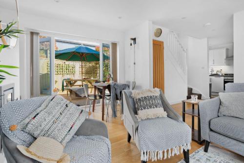 a living room with chairs and a table with an umbrella at Vickery's Cottage - Free Parking, Free WiFi, Pet Friendly in Woodbury
