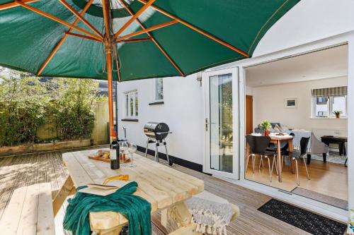 a patio with a table and an umbrella at Vickery's Cottage - Free Parking, Free WiFi, Pet Friendly in Woodbury