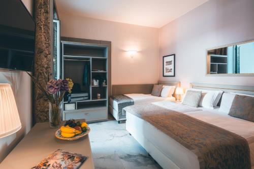 una camera d'albergo con due letti e una televisione di Hotel Palazzo Benci a Firenze