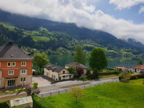 a small village with a lake and a mountain at Haus Feldseeblick in Feld am See