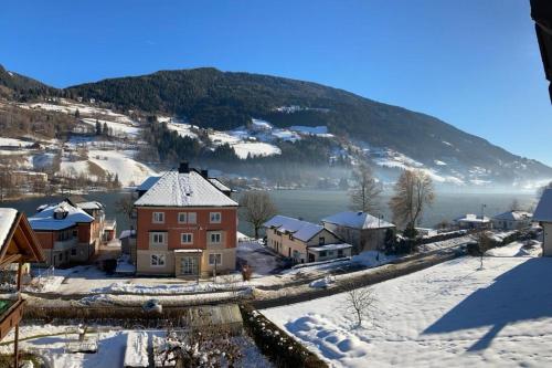 a town covered in snow with a mountain in the background at Haus Feldseeblick in Feld am See