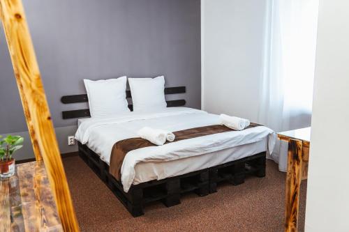 a bedroom with a bed with white sheets and a mirror at Casa Rosu in Cluj-Napoca