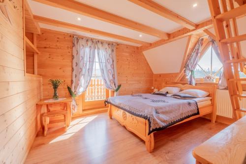 a bedroom with a bed in a wooden house at Domek za Wierchem in Małe Ciche