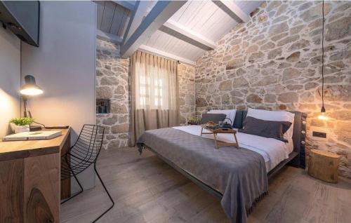 um quarto com uma cama e uma parede de pedra em Villa Dvori em Vržnaveri