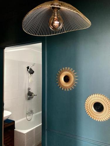 - une salle de bains avec un mur bleu et deux miroirs dans l'établissement Stylish and Cozy, à Asnières-sur-Seine