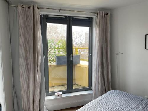 - une chambre avec une fenêtre et un lit à côté dans l'établissement Stylish and Cozy, à Asnières-sur-Seine