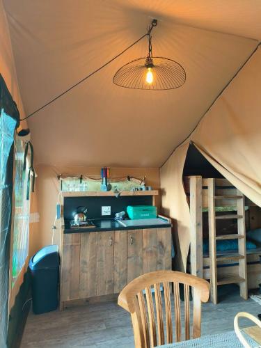 a room with a table and a chair in a tent at Luxe safaritent in Ballum