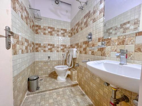 La salle de bains est pourvue d'un lavabo et de toilettes. dans l'établissement Aero Hotel, à Yelahanka