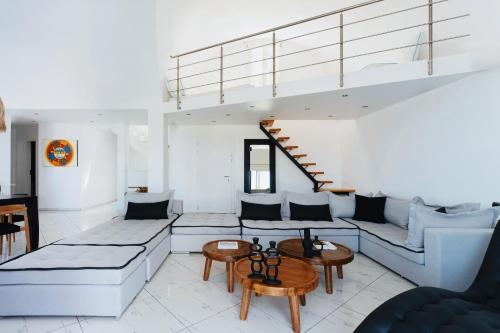 a living room with a couch and a staircase at The Zen Villa in Akrotiri