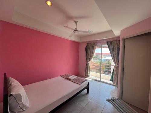 a bedroom with a bed and a red wall at Bonita House in Bangkok