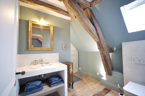 een badkamer met een wastafel en een spiegel bij Le Petit Serrant - maison d'hôtes d'exception in Bouchemaine