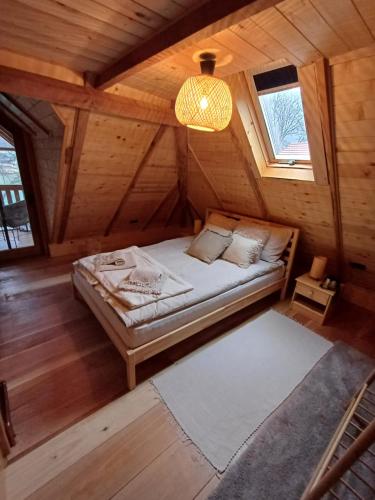 a bedroom with a bed in a wooden cabin at Drinska Dama in Bajina Bašta