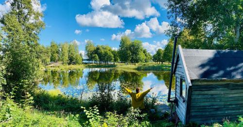 a person standing in the water near a lake at Romantic Cabin right on the lake with fire place in Stjärnsund