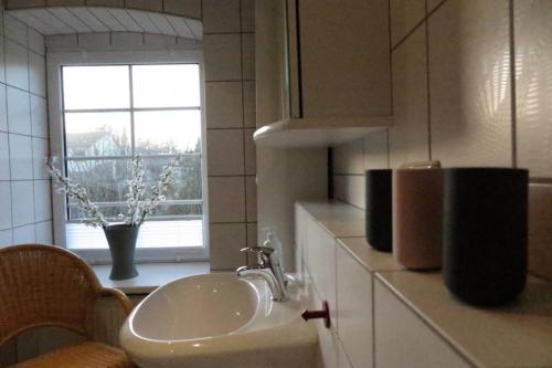 a white sink in a kitchen with a window at Ruhige FeWo im Nussbaumhof - Komfort & historisches Ambiente in Plath
