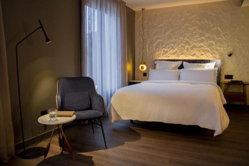 a hotel room with a bed and a chair at Letoh Letoh San Sebastián in Donostia-San Sebastián