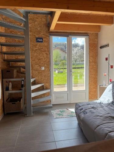 - une chambre avec une porte, un escalier et un lit dans l'établissement Gîte chez Marco, à Peyrieu
