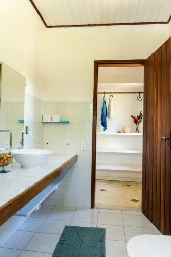 a bathroom with a tub and a sink and a mirror at Villa Arandis - Bangalô 02 - PÉ NA AREIA in Marau