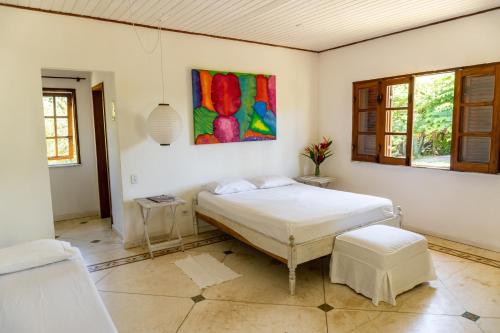 a bedroom with a bed and a painting on the wall at Villa Arandis in Marau