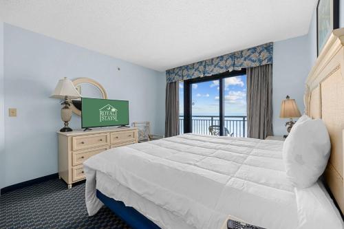 マートルビーチにあるOcean View Blues- Caribbean Resort 7th flのベッドと大きな窓が備わるホテルルームです。