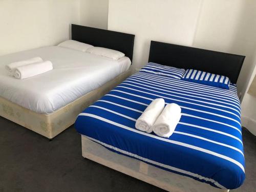 twee bedden in een kamer met handdoeken erop bij East London 2 bedroom flat in Londen