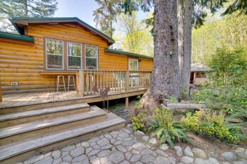 a log cabin with a deck and a tree at Moose Lodge Cabin with Entertainment Gazebo! in Baring