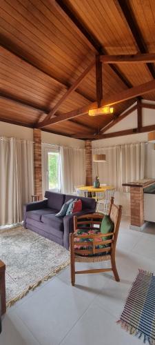 uma sala de estar com um sofá roxo e uma mesa em Pouso Mantiqueira em Cunha