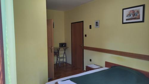 a bedroom with a bed and a door and a table at Mirna noć in Zagreb