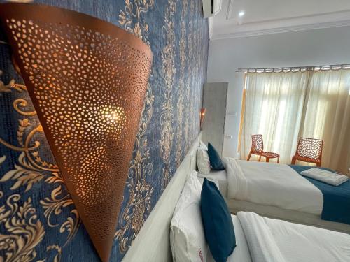 a hotel room with two beds and a wall at La Curcuma Luxury Homestay in Khajurāho
