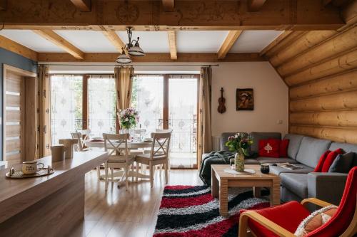 a living room with a couch and a table at Apartament Skibówki by LoftAffair in Zakopane