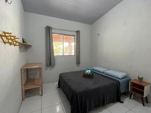 Un dormitorio con una cama azul y una ventana en Casa Recanto das Dunas, en Santo Amaro