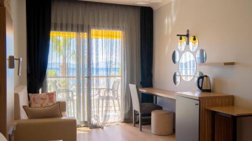 a room with a desk and a window with a chair at Sand Garden Hotel Bodrum in Bodrum City