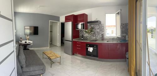 - une cuisine avec des placards rouges et un évier dans l'établissement Le Cacique 012, à Grand-Bourg