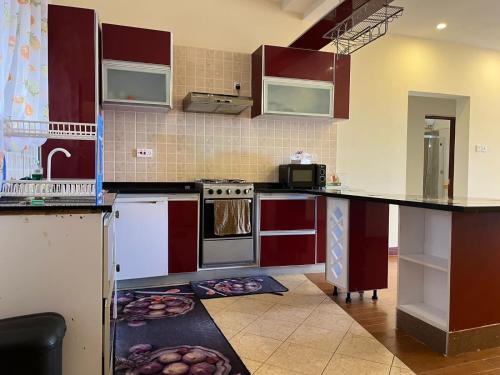 a kitchen with red cabinets and a counter top at The penthouse beachfront in Mombasa